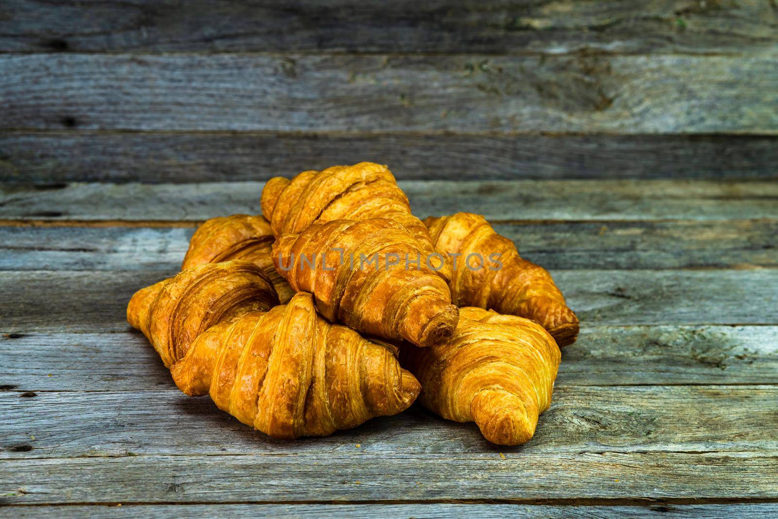 Delicious, fresh croissants isolated on wooden board. French breakfast concept.