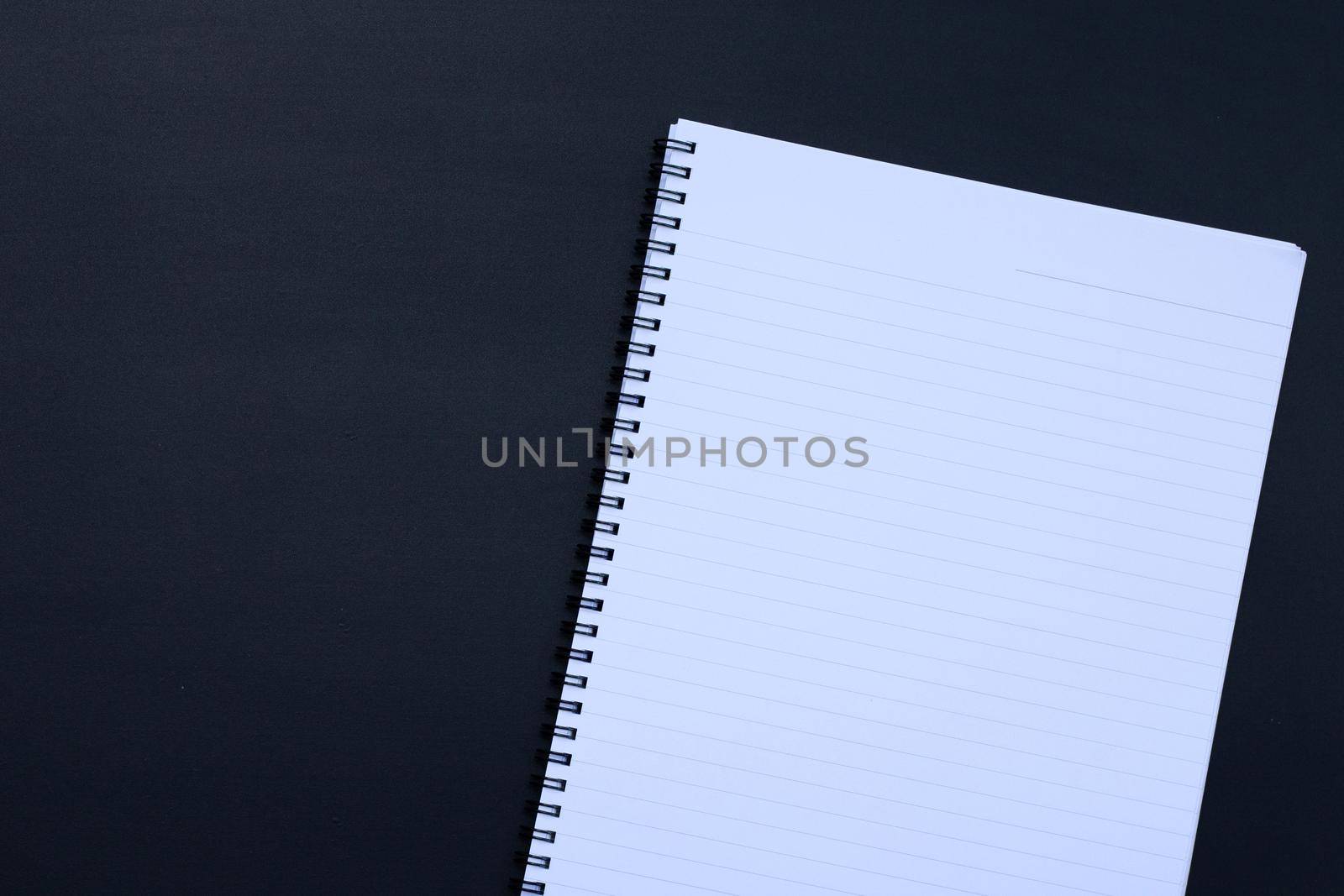 Open notebook on dark background. Top view