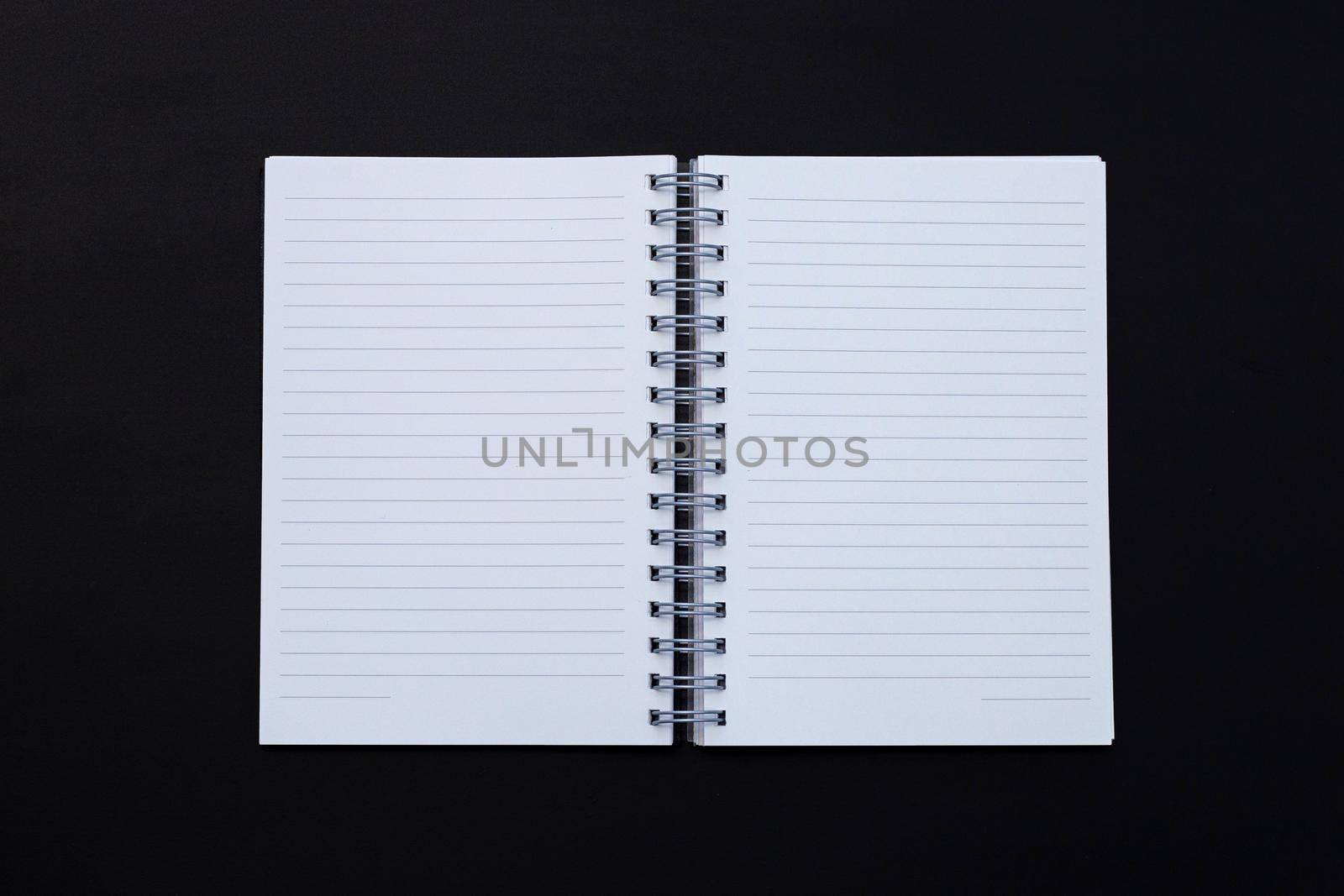 Open notebook on dark background. Top view