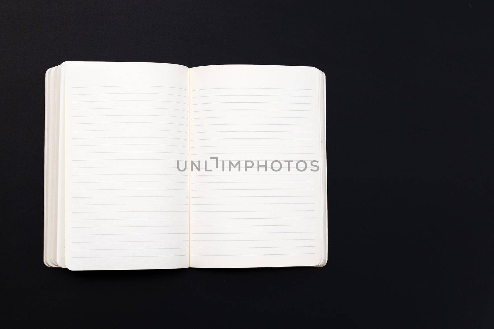 Open notebook on dark background. Top view