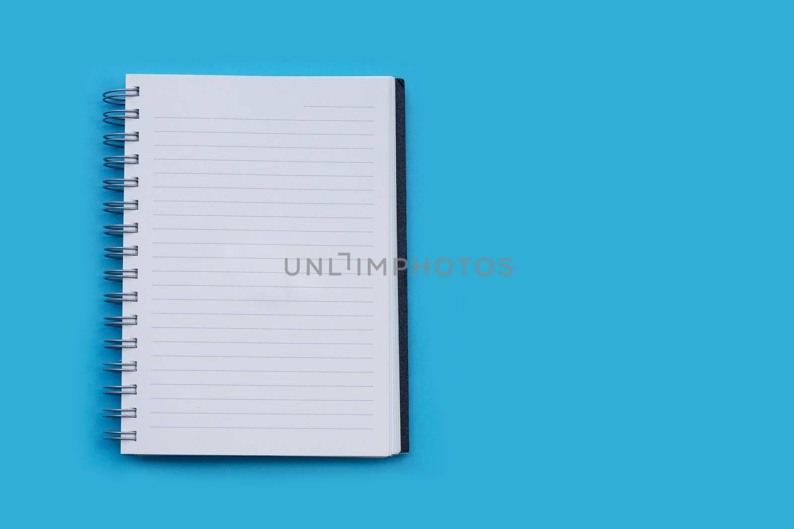 Open notebook on blue background. Top view