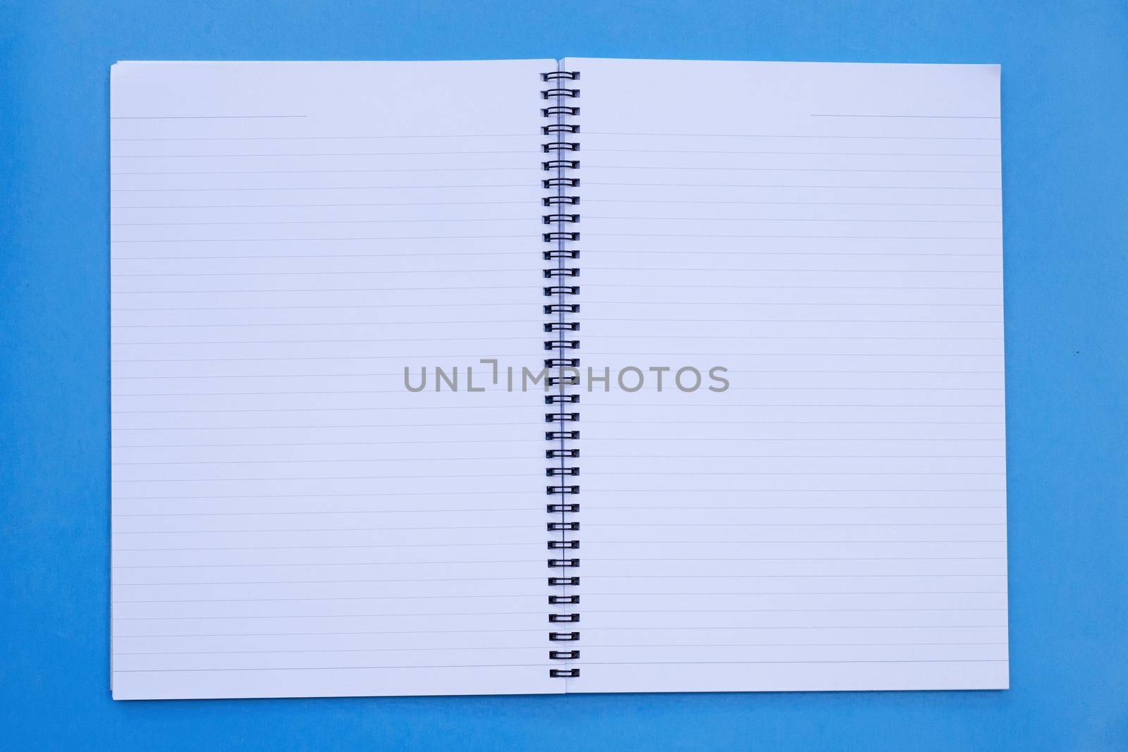Open notebook on blue background. Top view