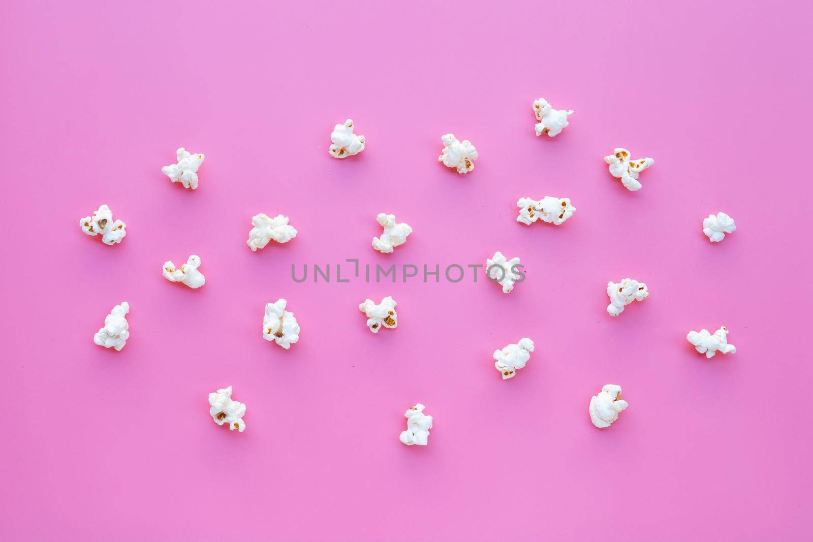 Popcorn on pink background. Copy space