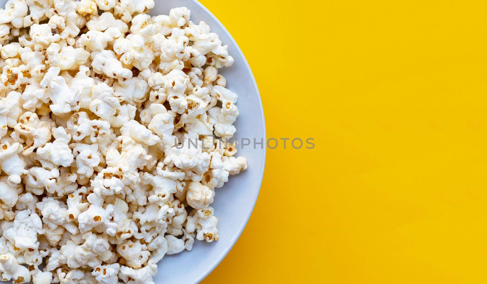 Popcorn on yellow background. Copy space