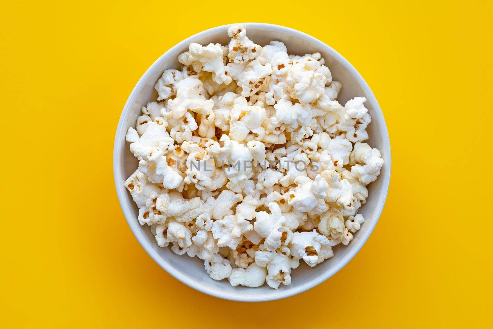 Popcorn on yellow background. Copy space