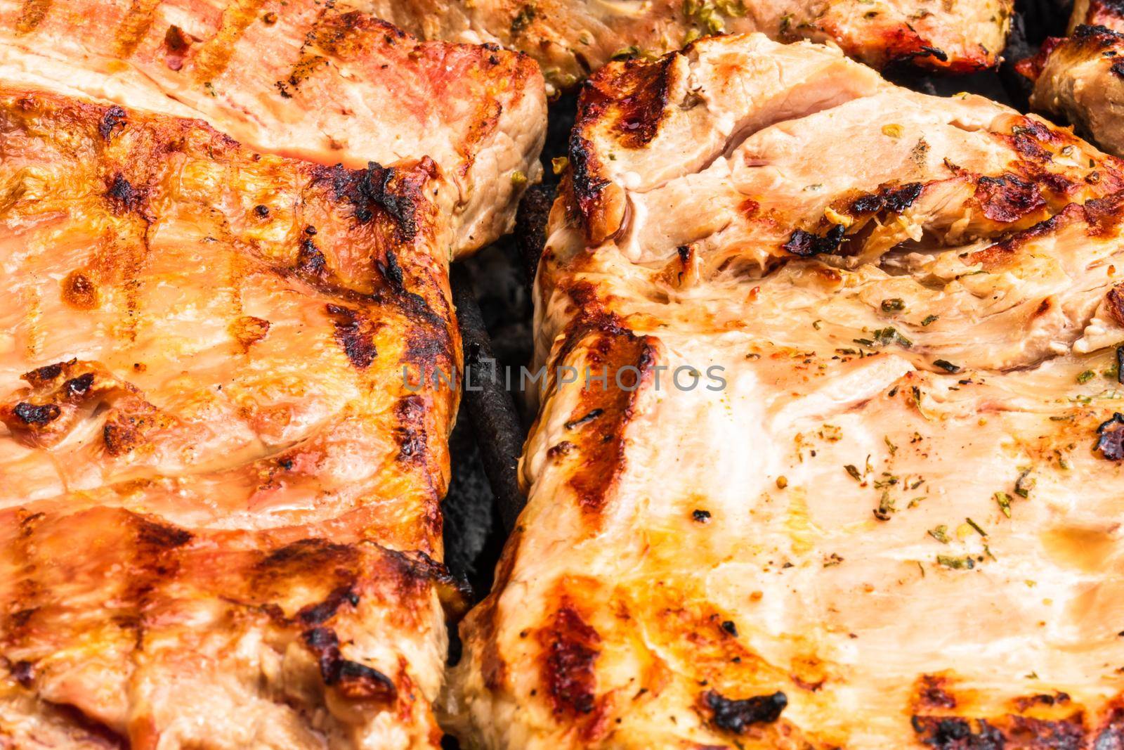 Close up of pork steak grilled on a charcoal barbeque isolated. by vladispas