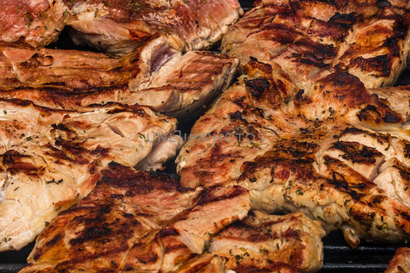 Close up of pork steak grilled on a charcoal barbeque isolated.