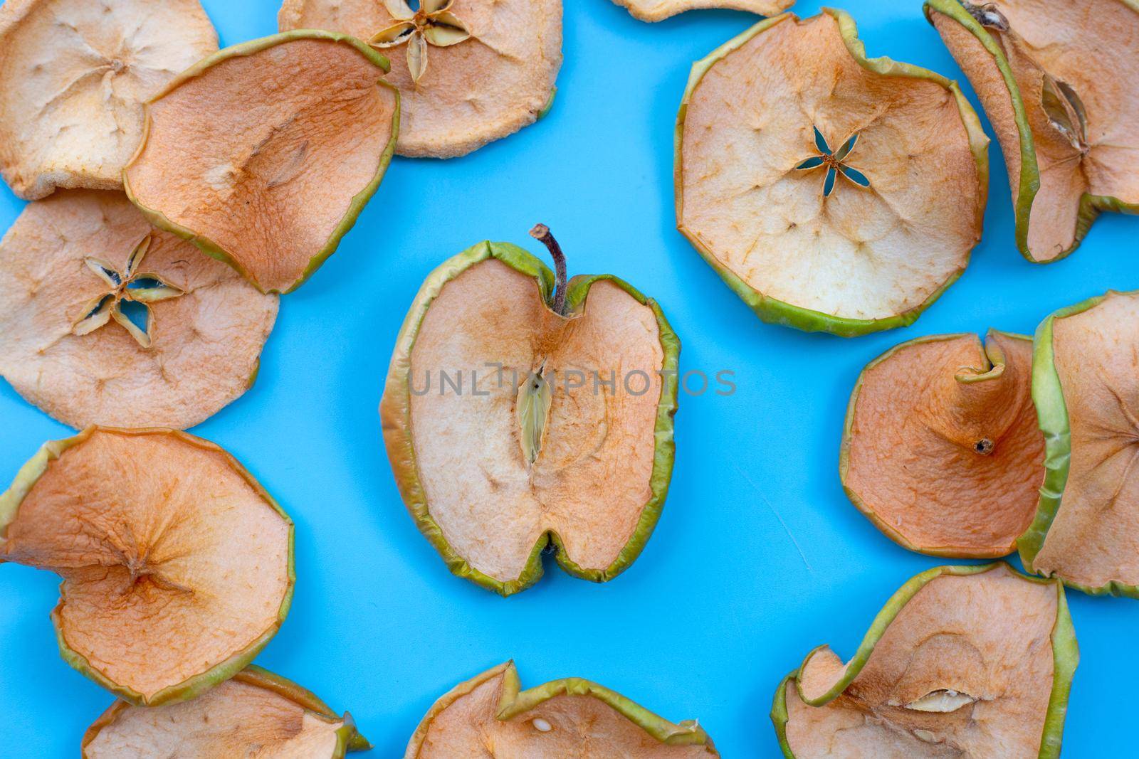 Dried apple slices on blue background