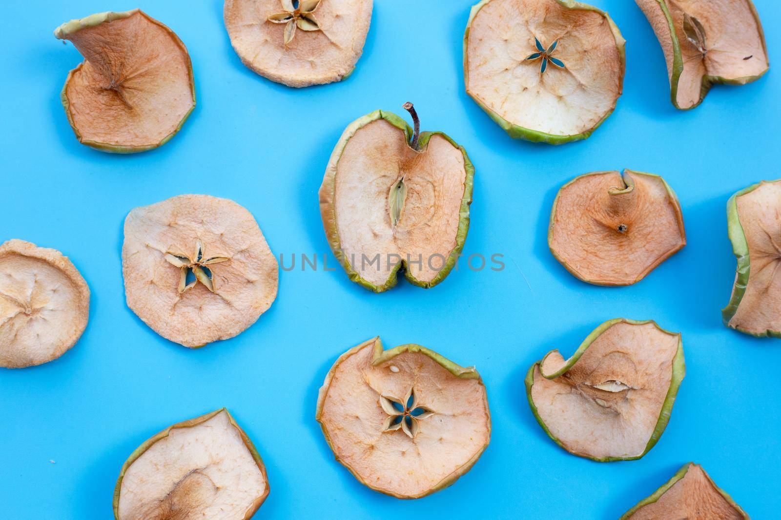 Dried apple slices on blue background