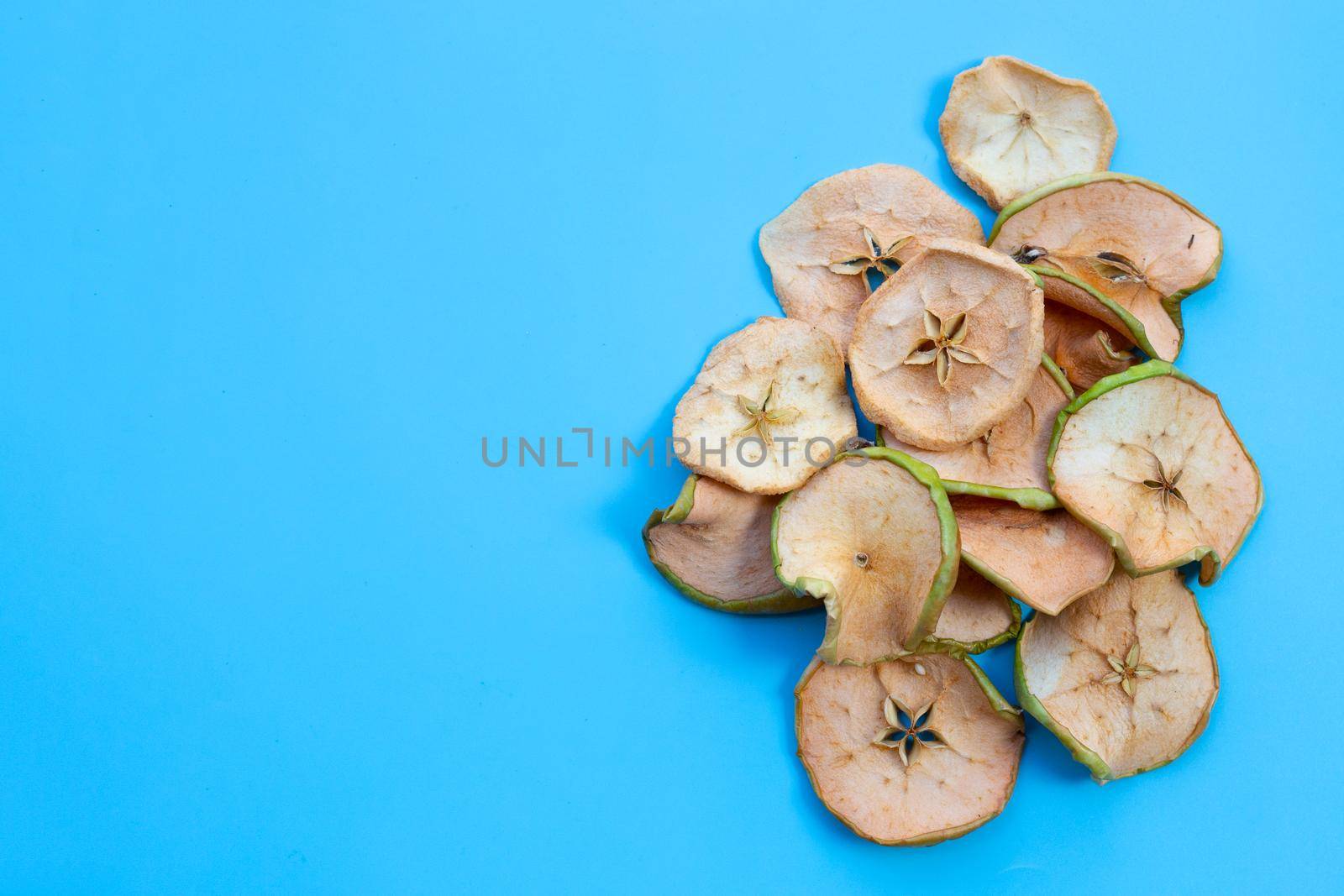 Dried apple slices on blue background