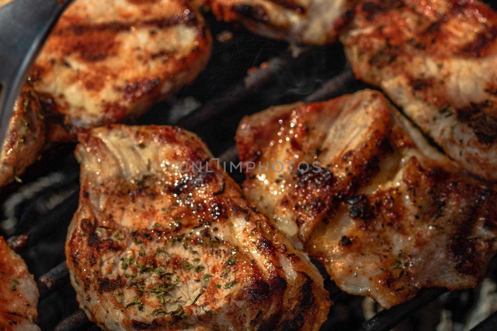 Grilling pork steaks. Delicious meat steaks close up cooking on the barbecue grill