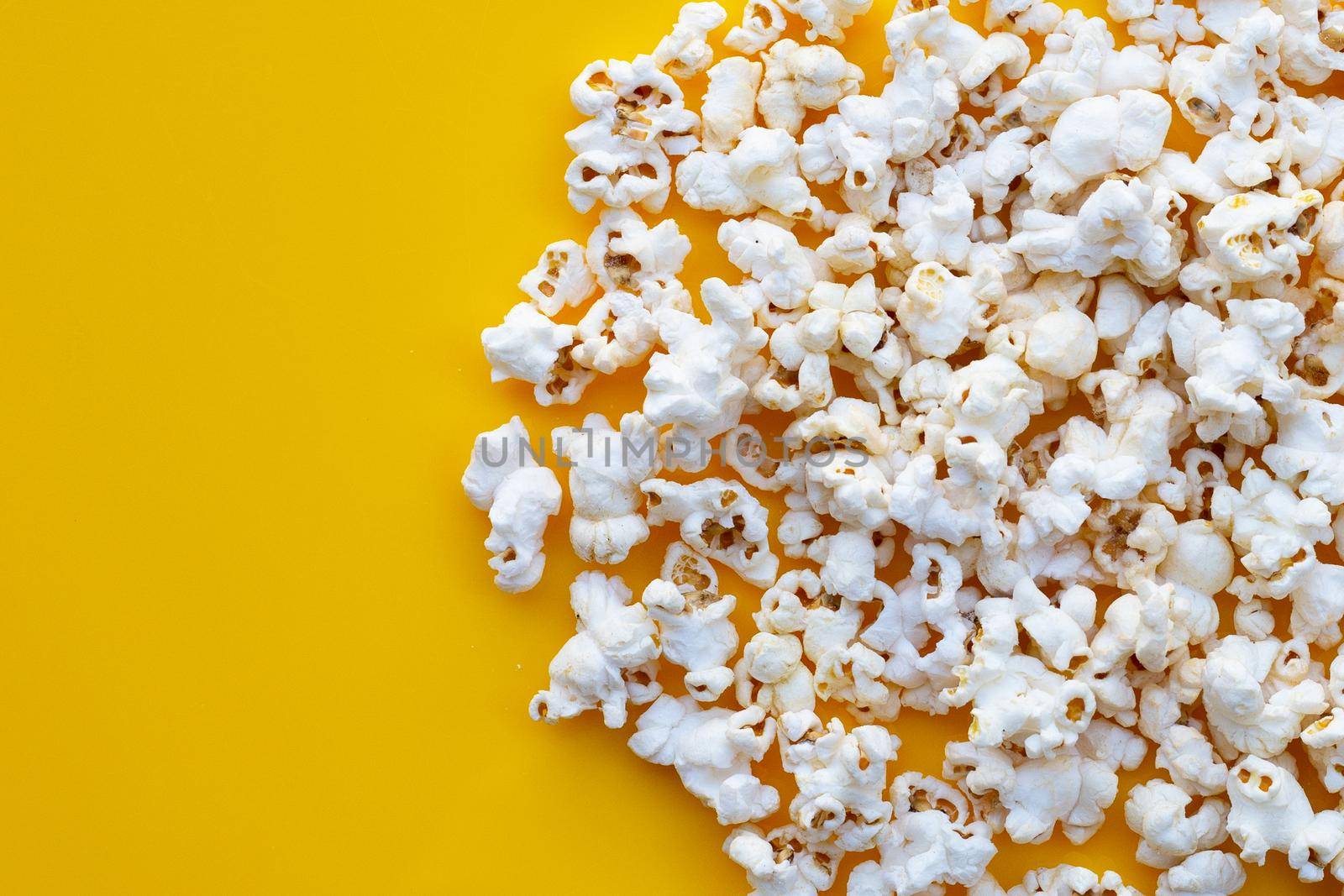Popcorn on yellow background. Copy space by Bowonpat