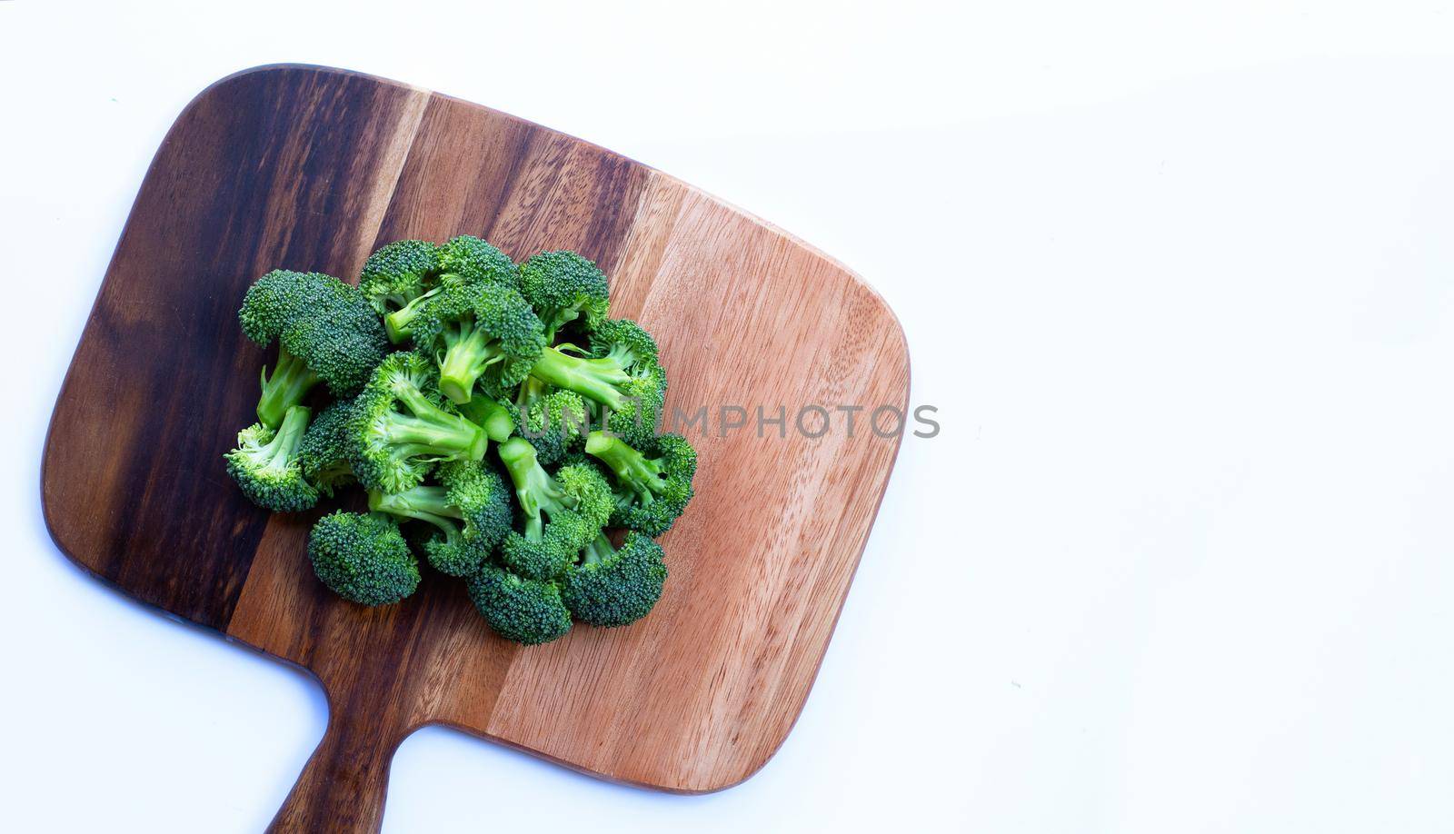 Fresh green broccoli on wooden cutting board by Bowonpat