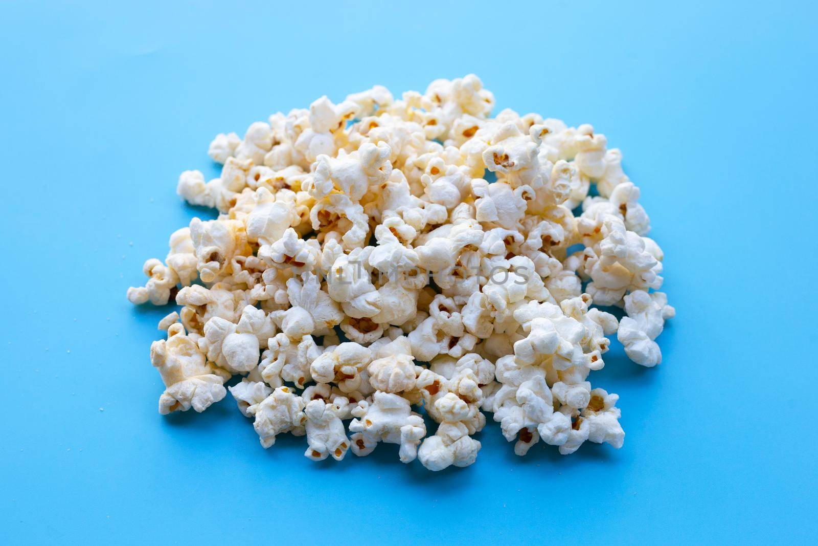 Popcorn on blue background. Copy space