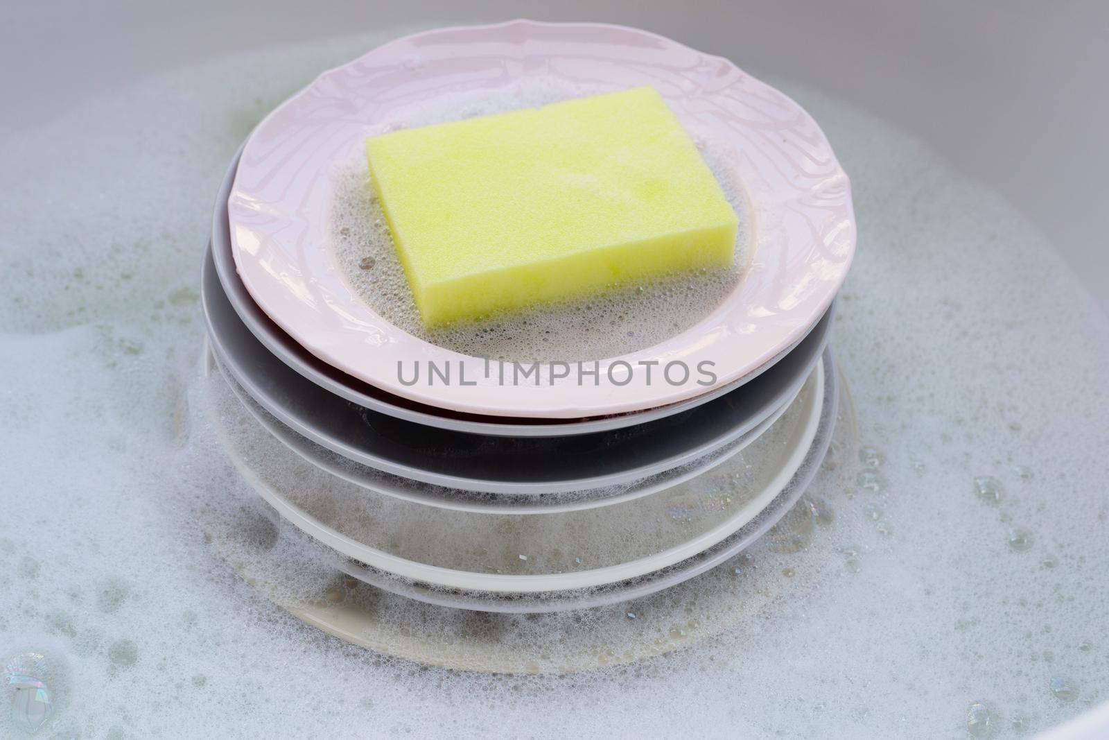 Washing dishes, Close up of utensils soaking in kitchen sink. by Bowonpat