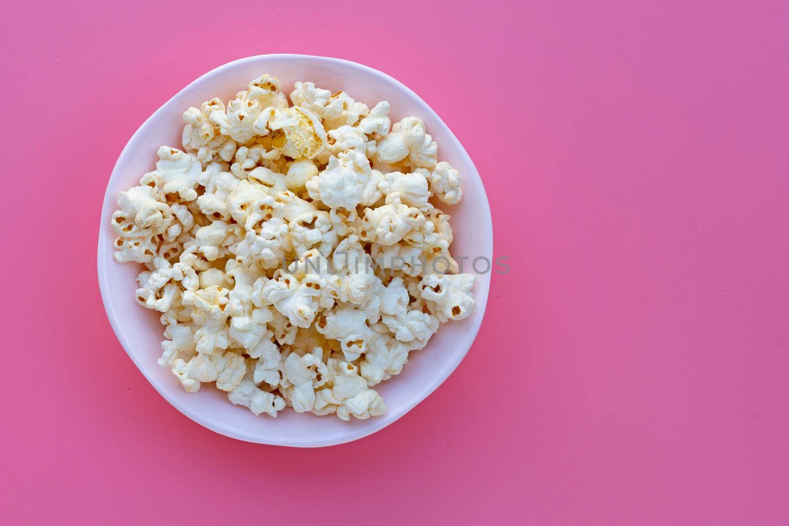 Popcorn on pink background. Copy space by Bowonpat