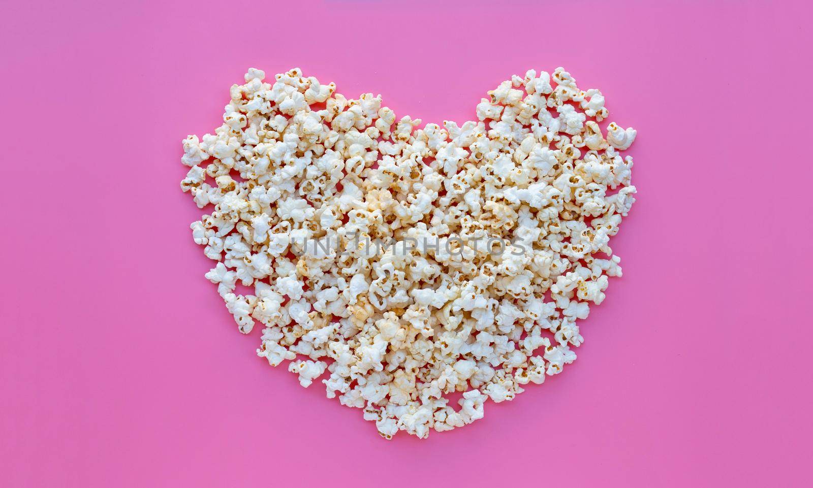 Popcorn on pink background. Copy space