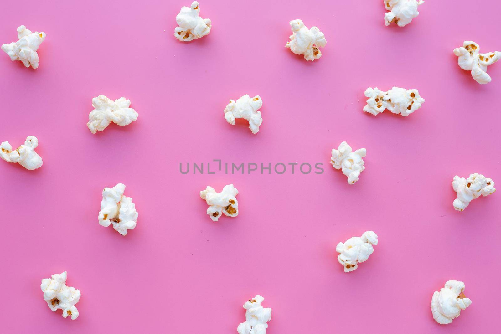 Popcorn on pink background. Copy space