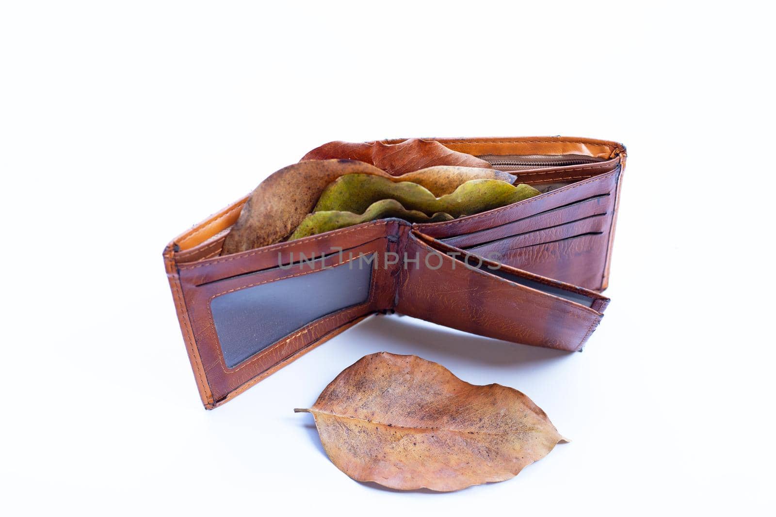 Wallet with dry leaves on white background. Poor or no money concept. by Bowonpat