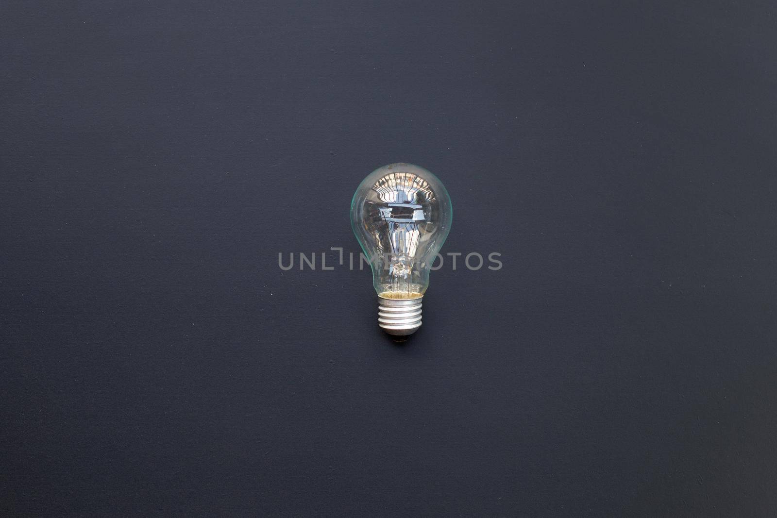 Light bulb on dark background. Ideas and creative thinking concept. Top view by Bowonpat