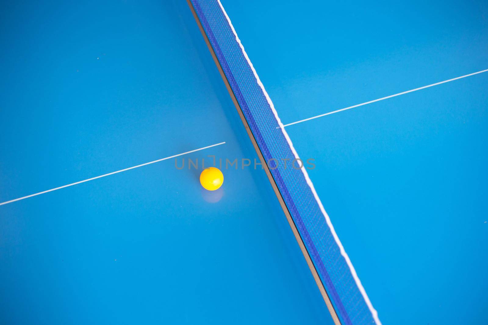 Net of table tennis ping pong with yellow ball on blue background. by Bowonpat