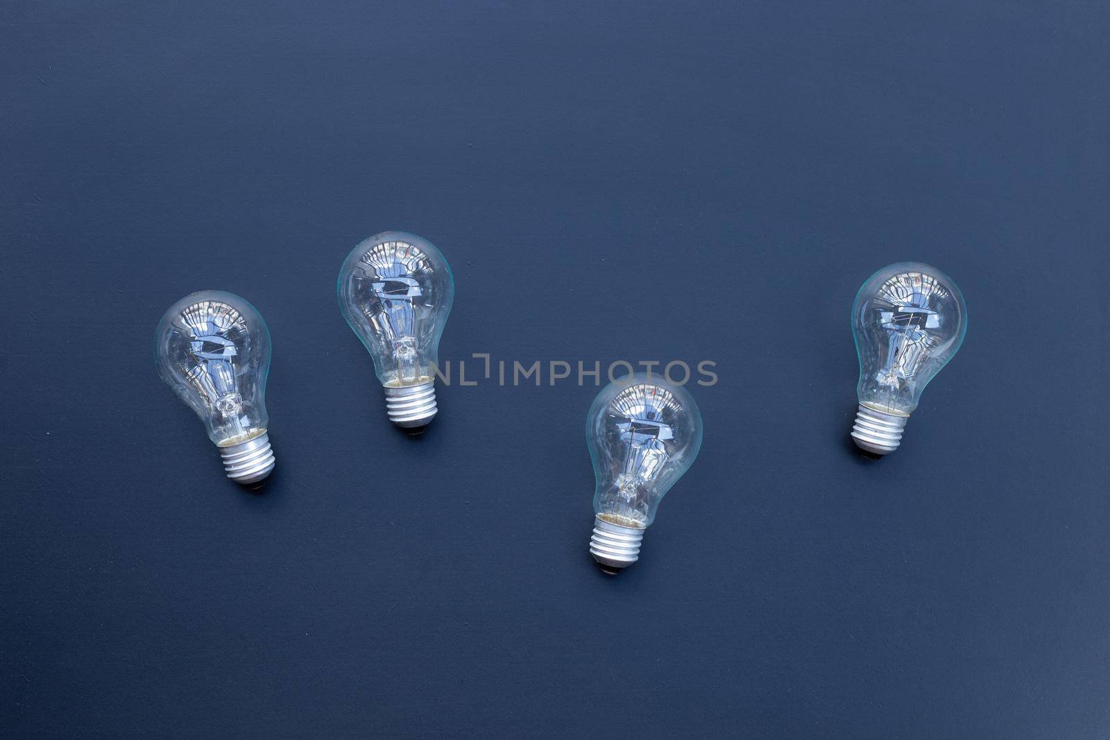 Light bulbs on dark background. Ideas and creative thinking concept. Top view