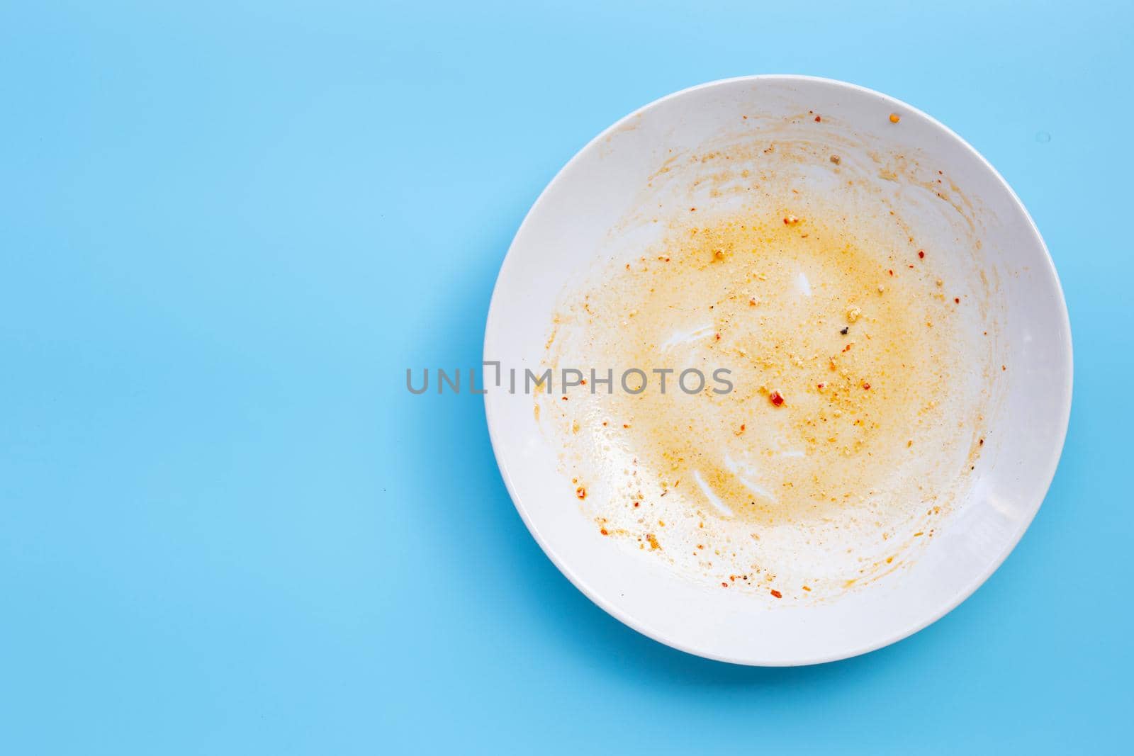 Dirty dish on blue background. by Bowonpat