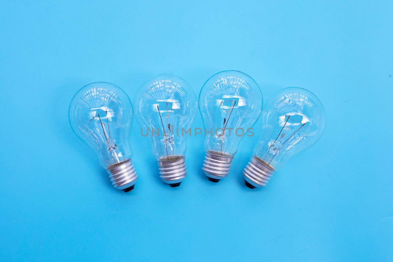 Light bulbs on blue background. Ideas and creative thinking concept. Top view by Bowonpat