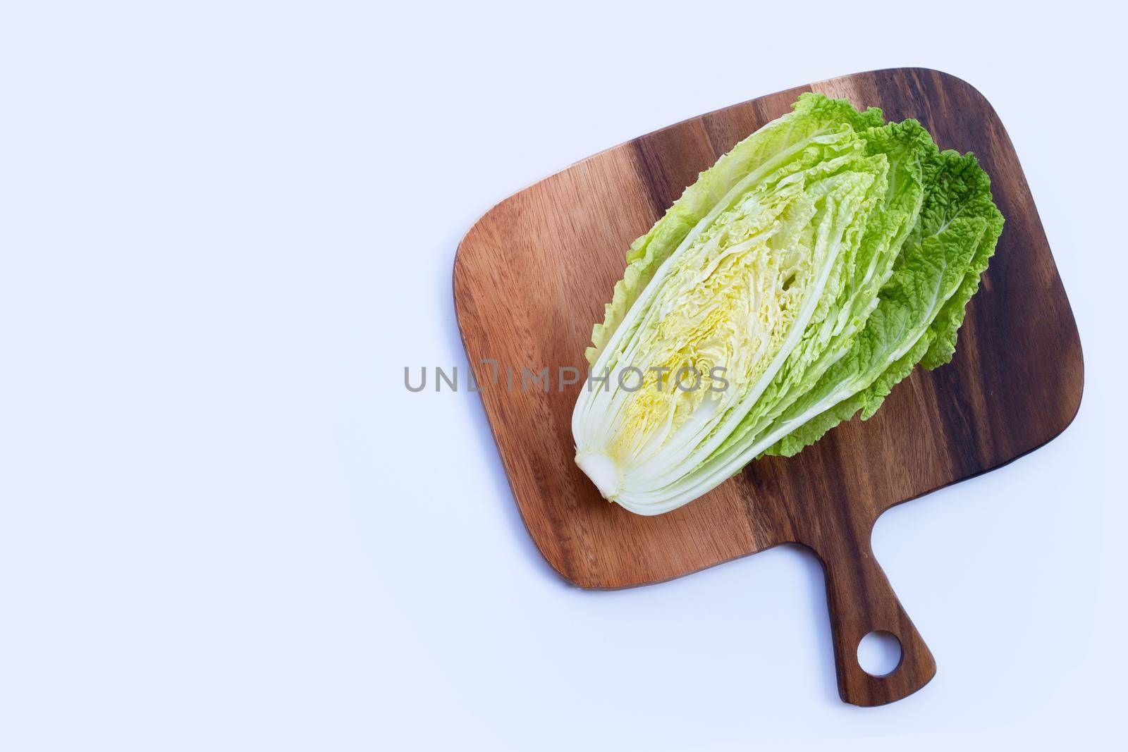 Chinese cabbage on wooden cutting board on white background. Copy space