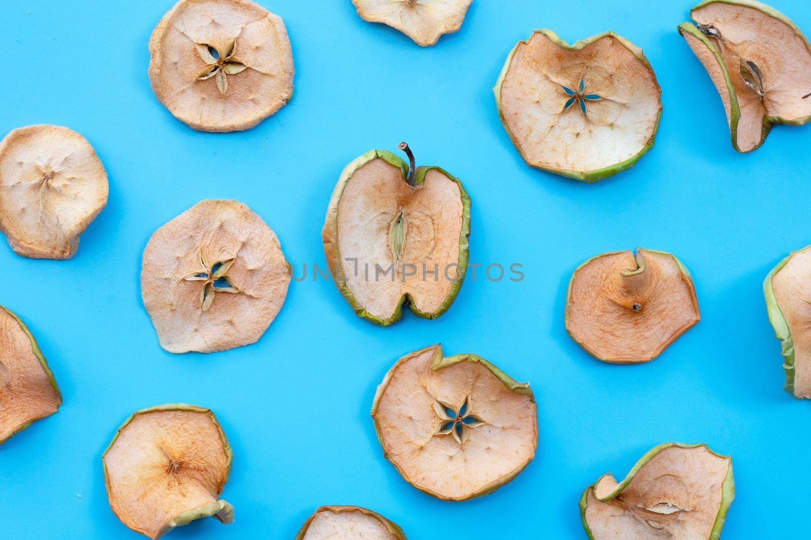 Dried apple slices on blue background by Bowonpat