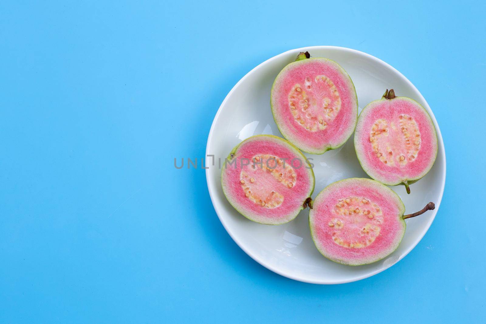 Pink guava on blue background. by Bowonpat