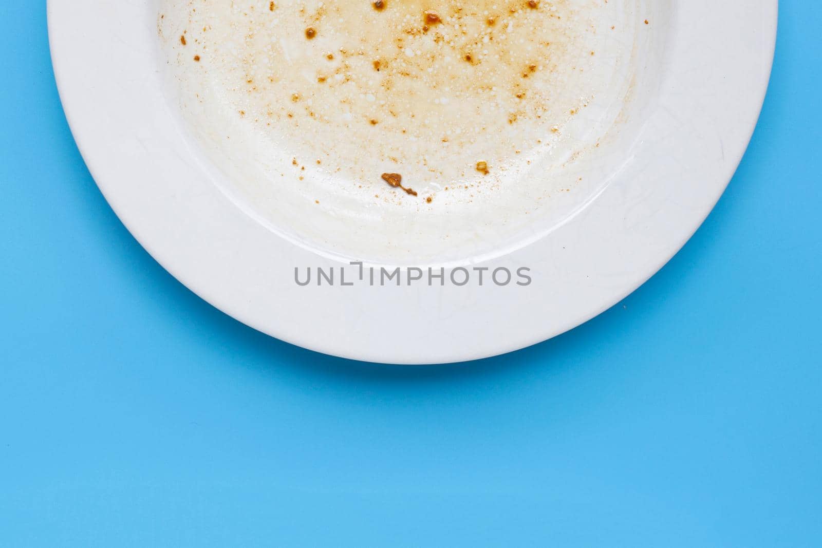 Dirty dish on blue background. by Bowonpat