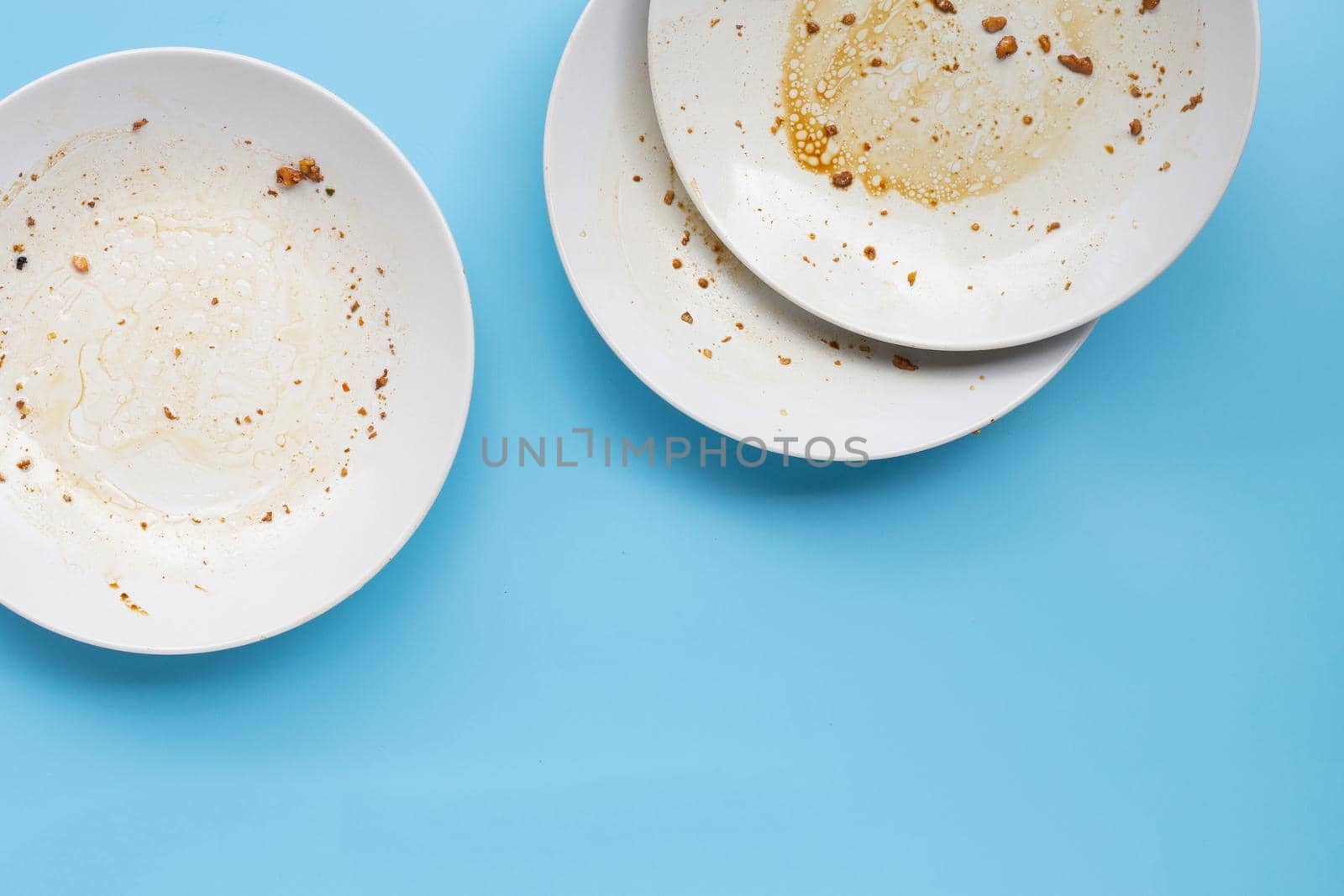 Dirty dishes on blue background. by Bowonpat