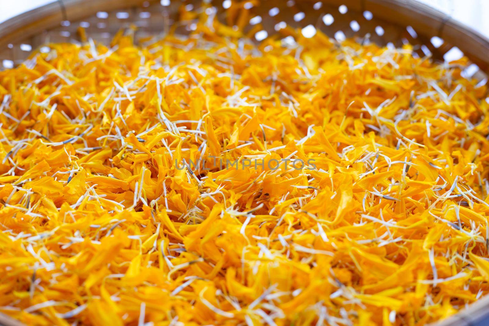 Petals of marigold flower in bamboo basket by Bowonpat