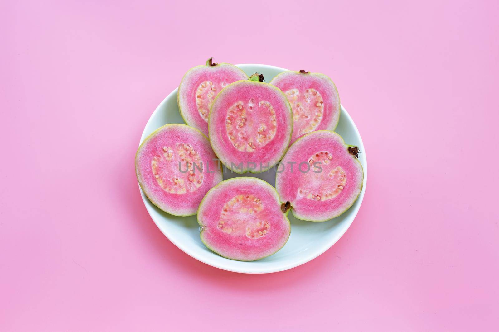 Pink guava on pink background. by Bowonpat