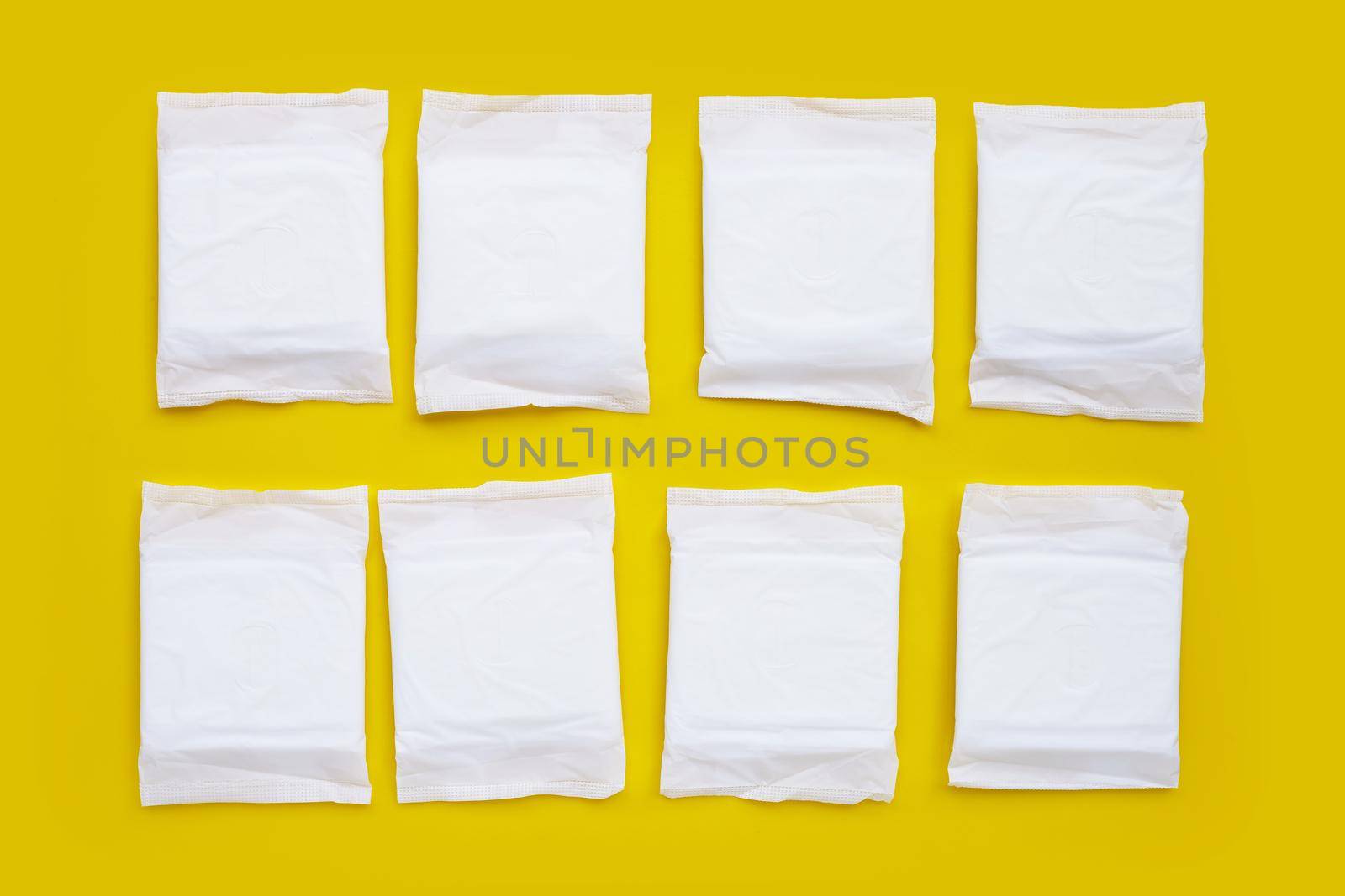 White sanitary napkin with red roses on yellow background.