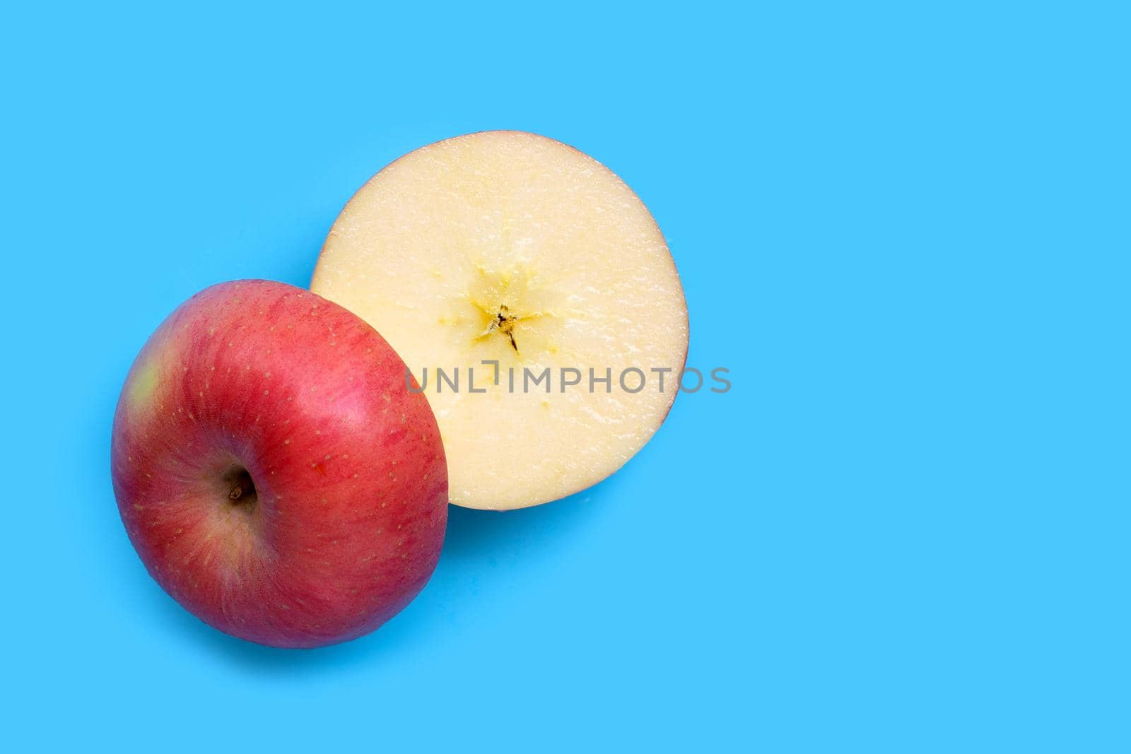 Ripe apple on blue background. by Bowonpat