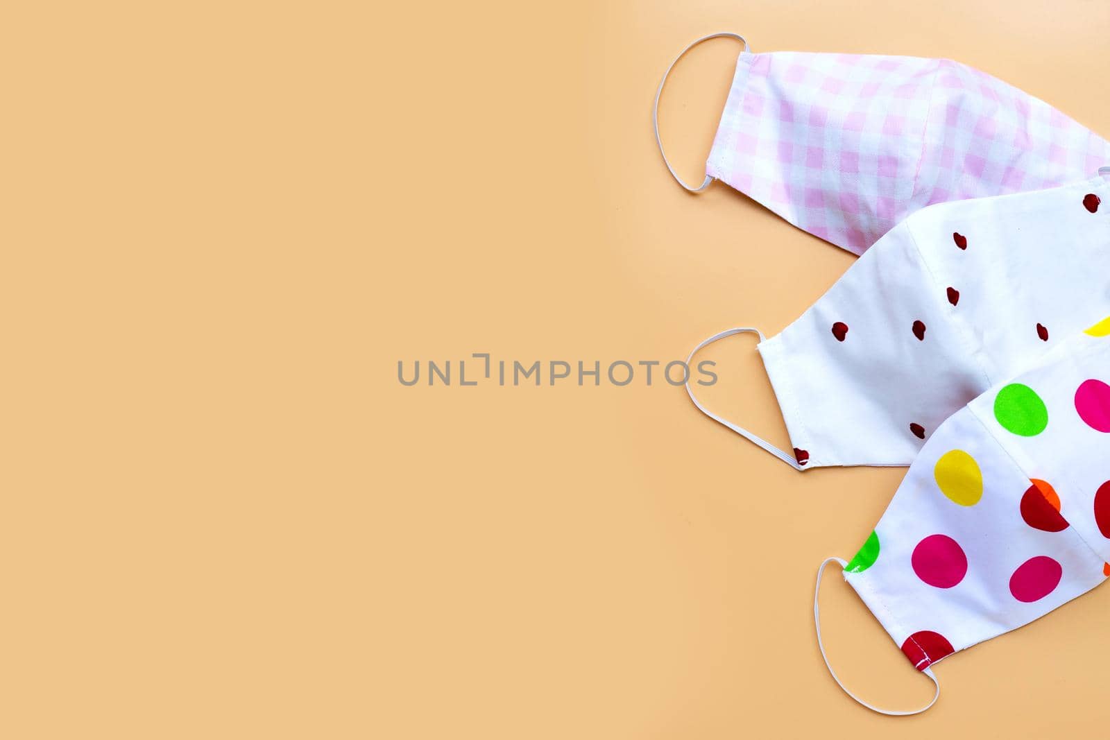 Handmade colorful cloth masks on yellow background.