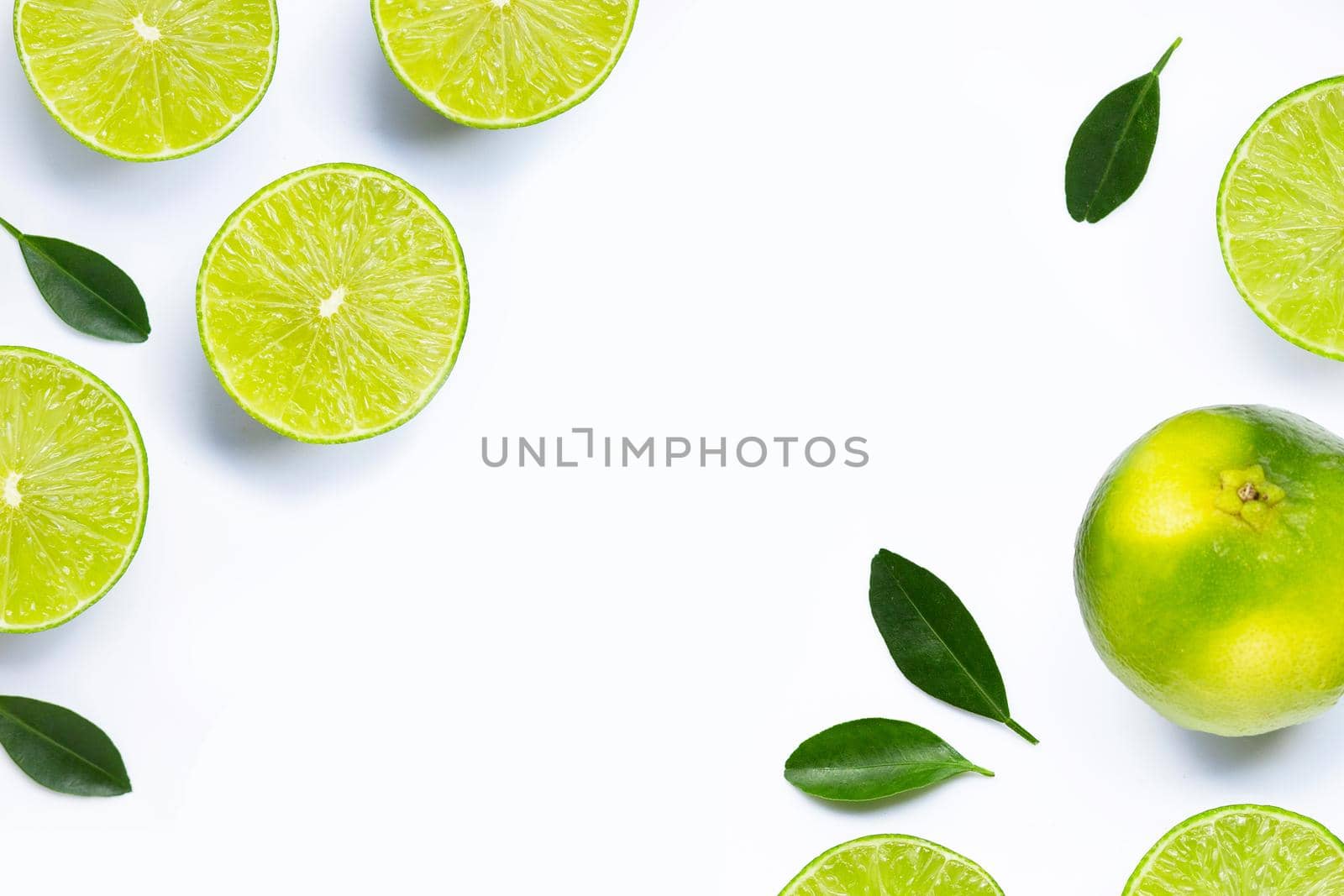 Frame made of fresh limes with leaves isolated on white background.