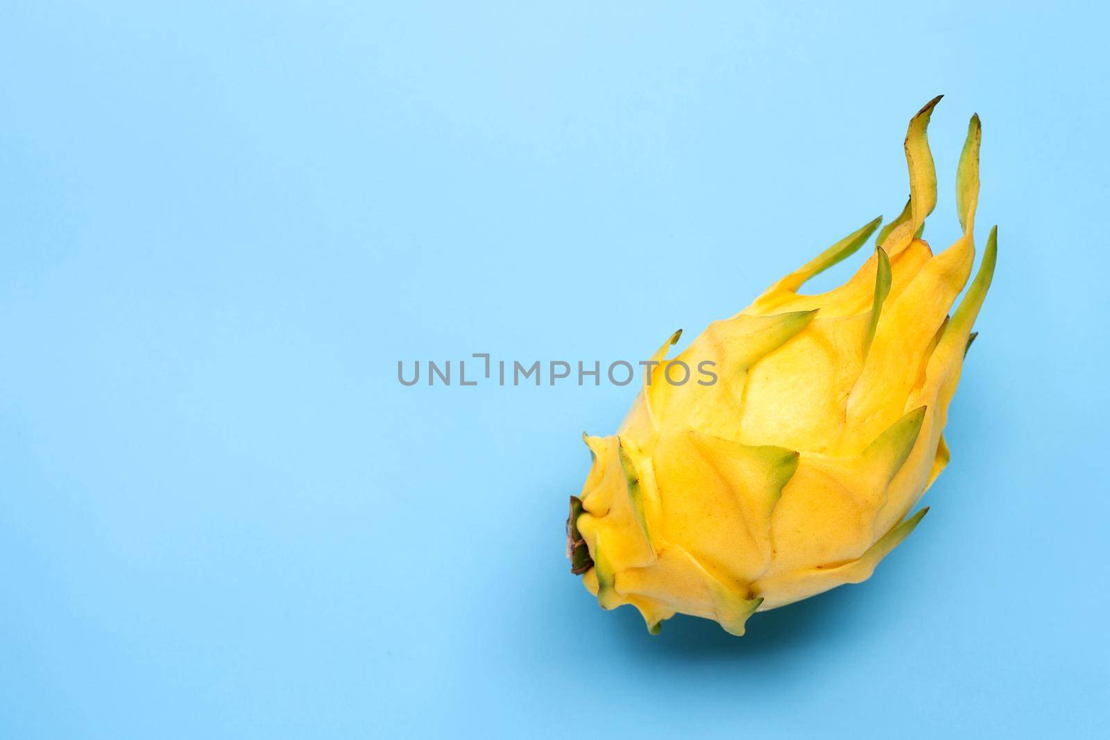 Yellow pitahaya or dragon fruit on blue background. Copy space