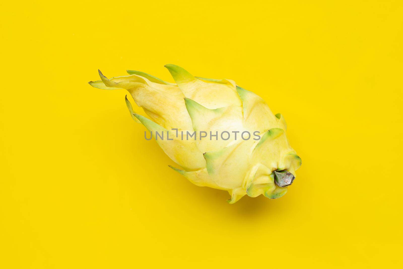 Yellow pitahaya or dragon fruit on yellow background. Copy space