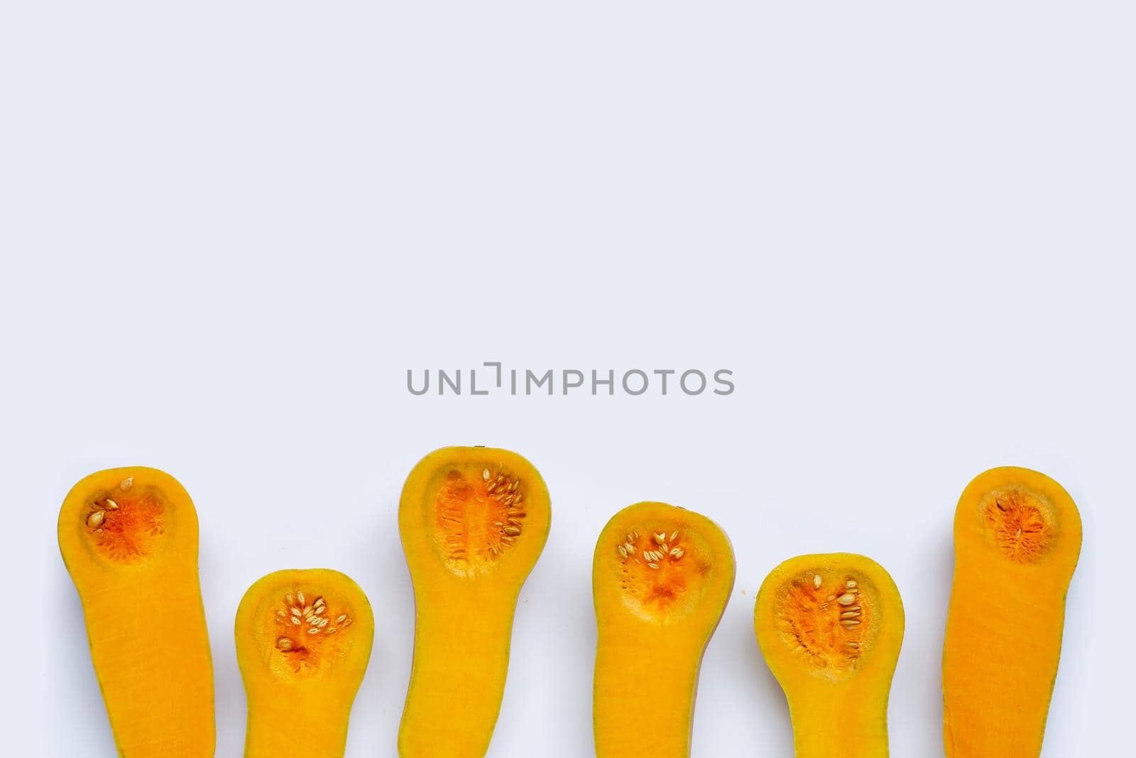 Cut and slices butternut squash on white background.