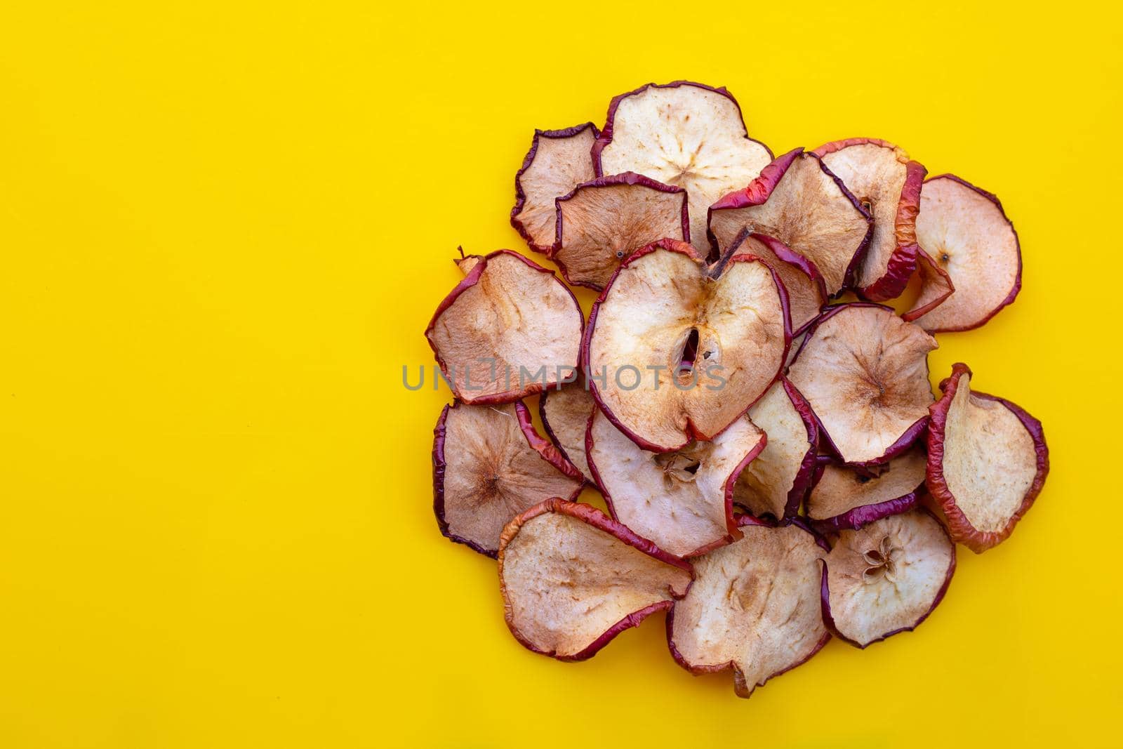 Dried apple slices on yellow background