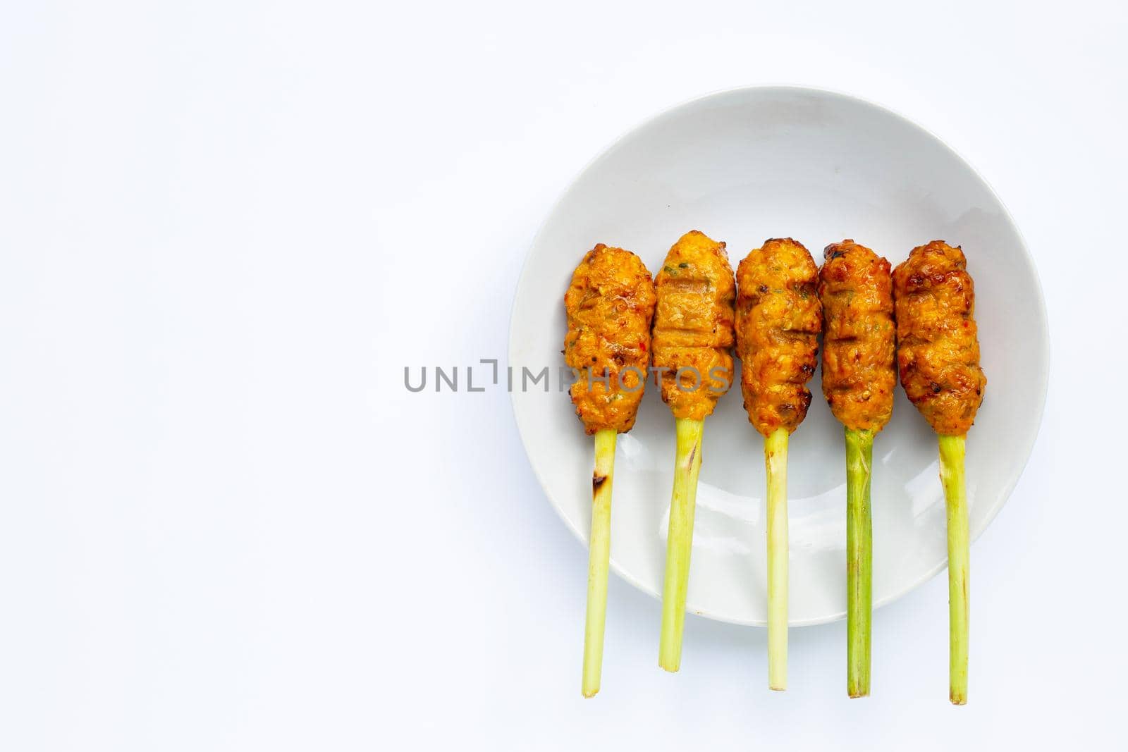 Grilled minced chicken with curry paste and coconut cream on lemongrass skewers. Top view