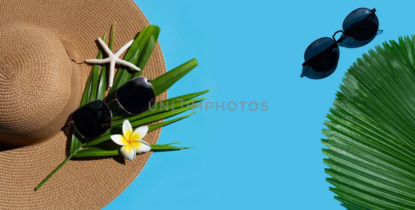 Summer hat with sunglasses on blue background. Enjoy holiday concept. Copy space