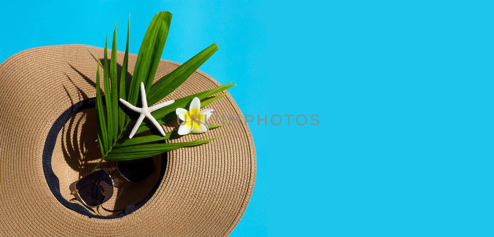 Summer hat with sunglasses on blue background. Enjoy holiday concept. Copy space