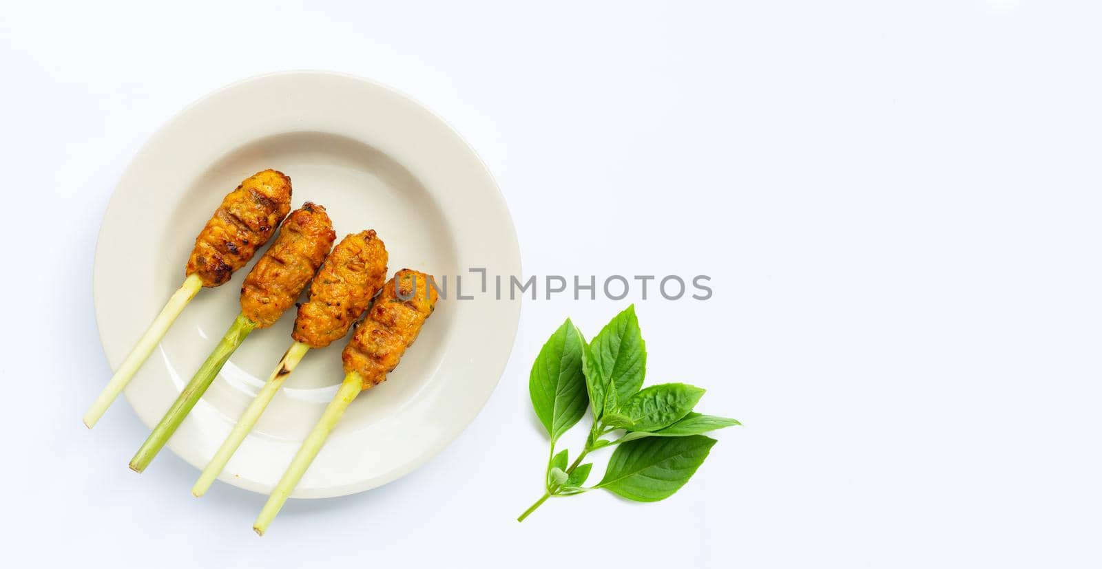 Grilled minced chicken with curry paste and coconut cream on lemongrass skewers. Top view