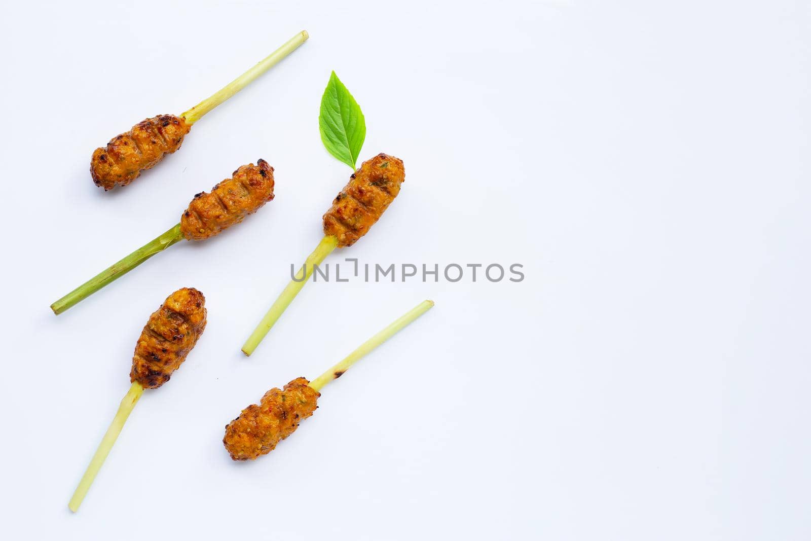 Grilled minced chicken with curry paste and coconut cream on lemongrass skewers. Top view