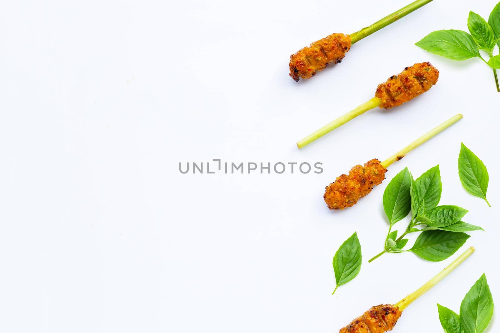 Grilled minced chicken with curry paste and coconut cream on lemongrass skewers. Top view