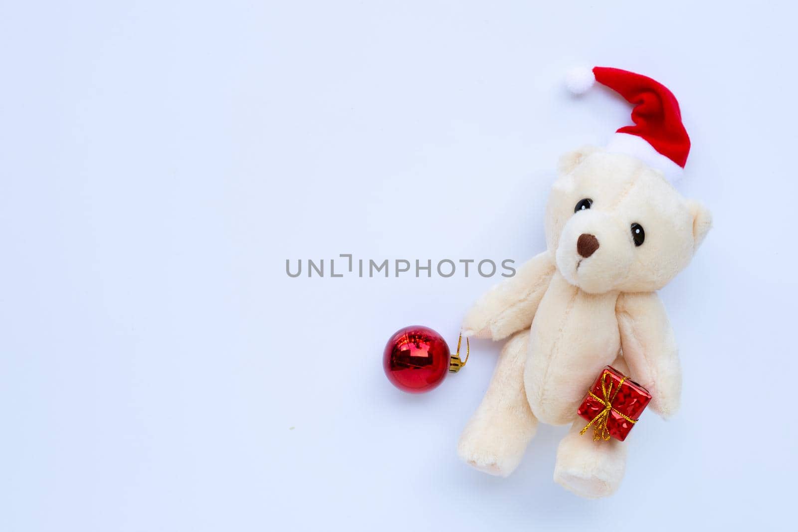 Toy bear wearing a santa hat on white background. Christmas holidays concept